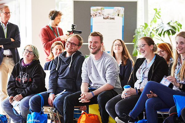 Das Bild zeigt mehrer junge Menschen, die im Plenum des Jugendaktionscamps 2019 sitzen und lachen © Anna Spindeldreiher, 2019