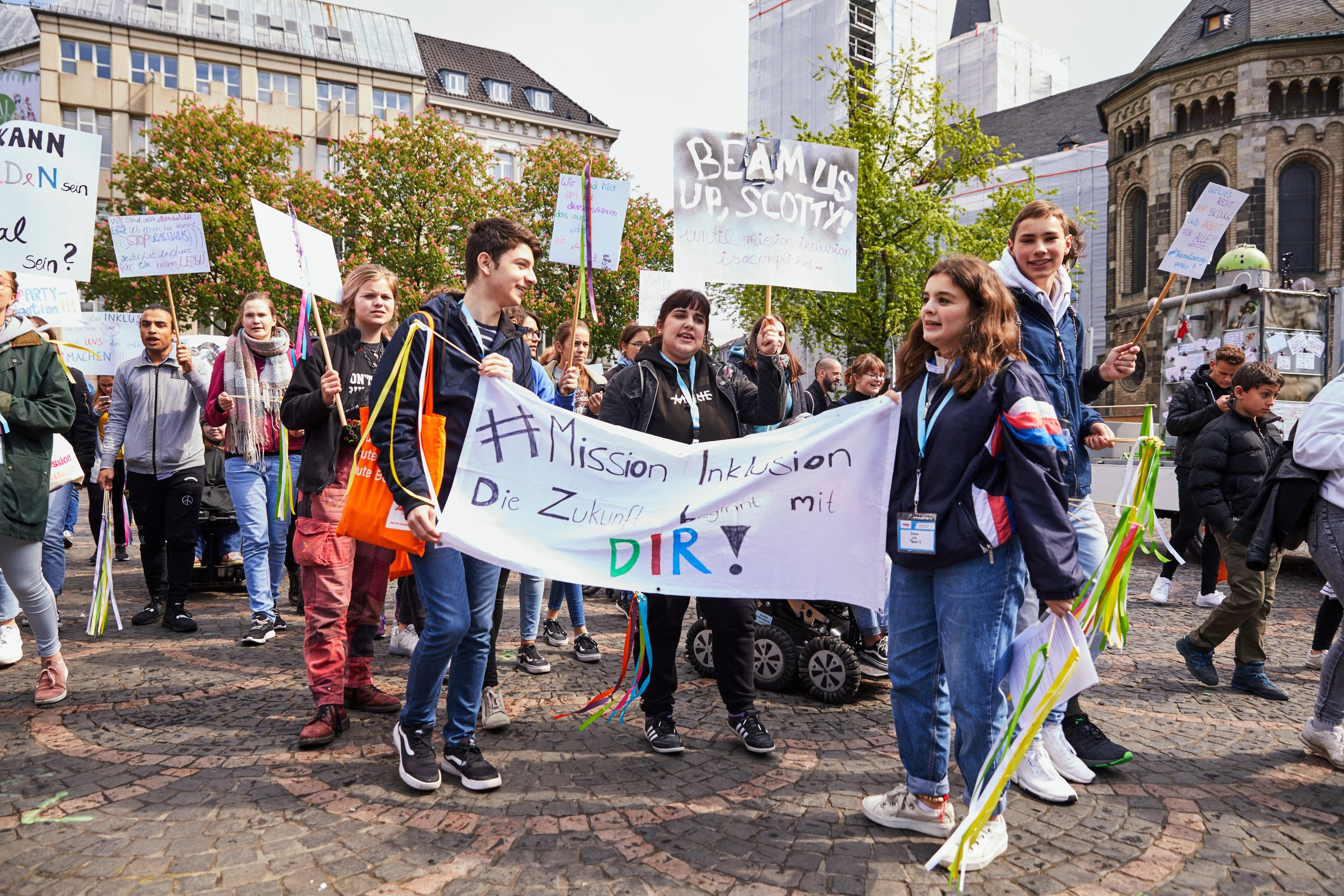 Auf dem Bild sind mehrere junge Menschen zu sehen, die auf der Straße demonstrieren. Sie halten Plakate und Schilder in die Höhe. © Servicestelle Jugendbeteiligung e.V., 2019