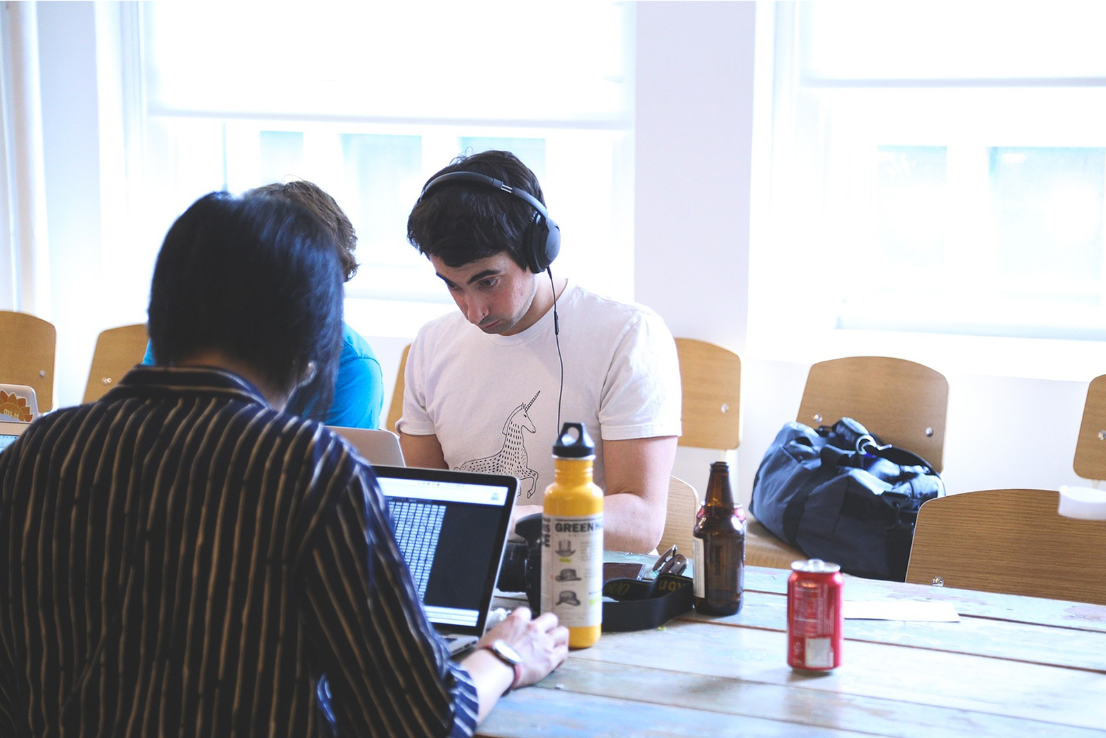 Das Bild zeigt drei Menschen, die gemeinsam an einem Tisch sitzen und auf ihre Laptops schauen. © Servicestelle Jugendbeteiligung e. V., 2021