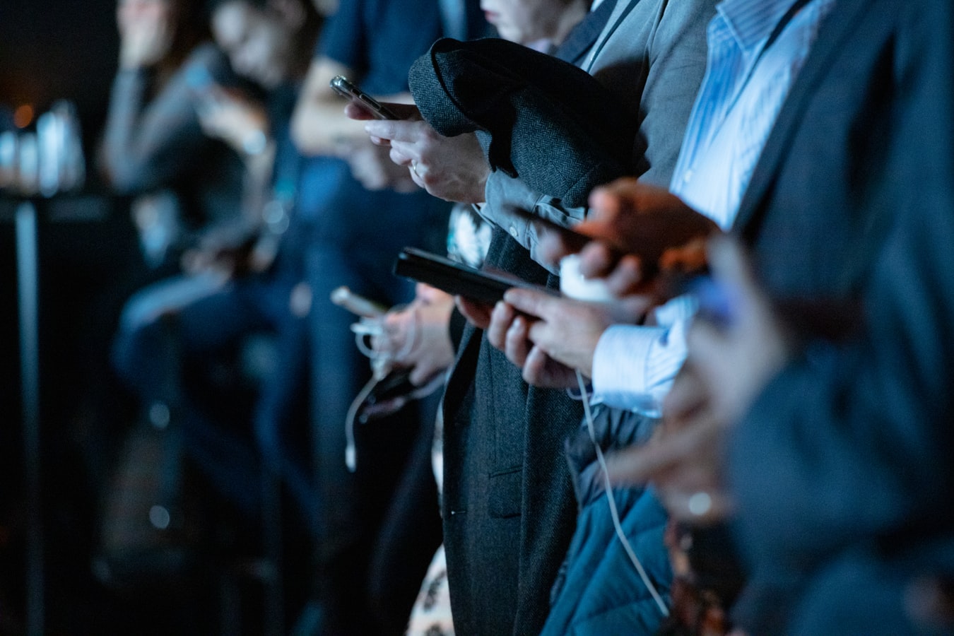 Es sind mehrere Menschen mit Smartphone in der Hand zu sehen.