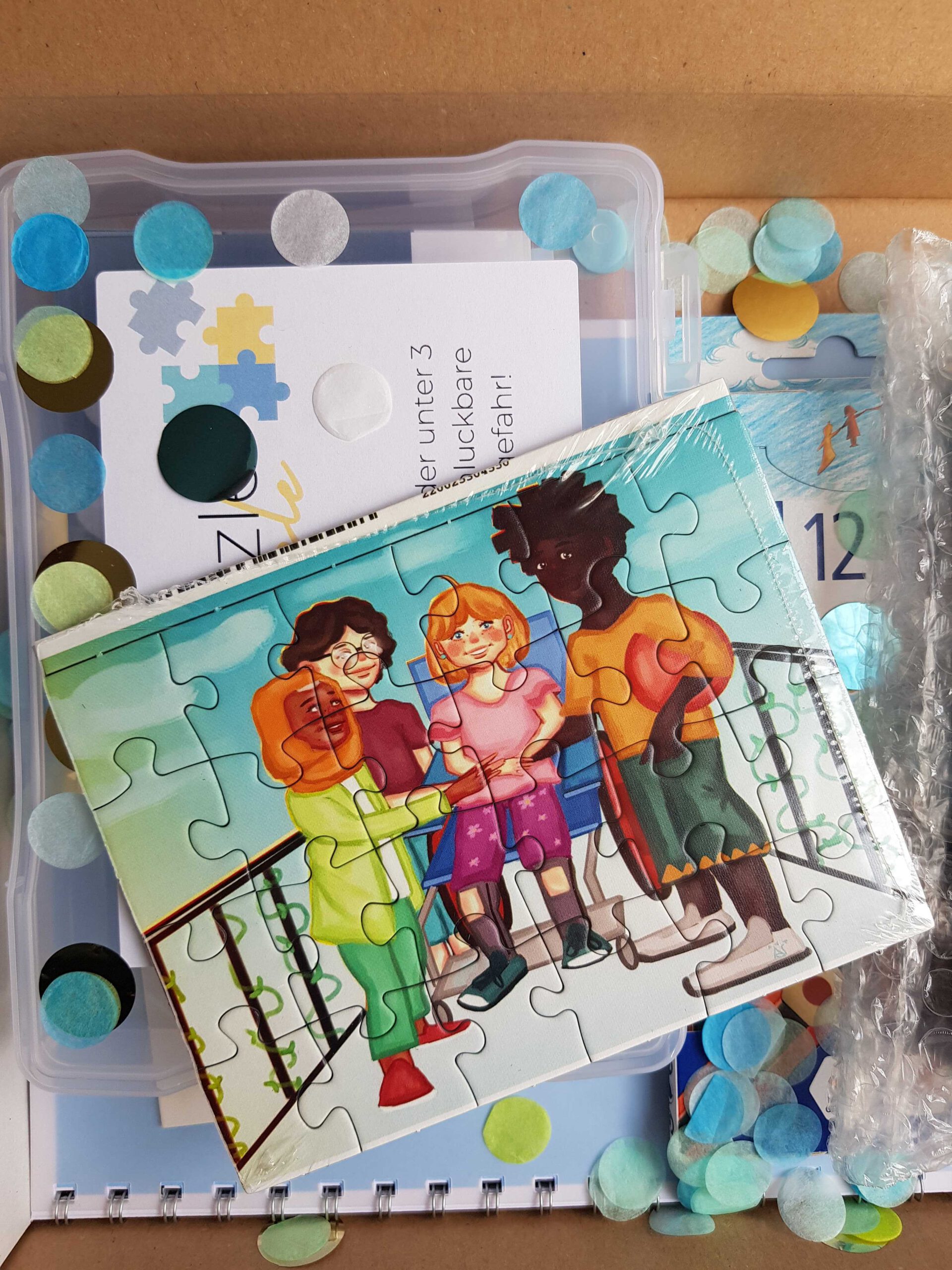 Das Bild zeigt das Puzzle der Inklusiven Kreativbox. Auf dem Puzzlemotiv ist eine vielfältige kleine Gruppe von Kindern zu sehen, die auf einer Brücke stehen und freundlich lachen. © Servicestelle Jugendbeteiligung e.V., 2021