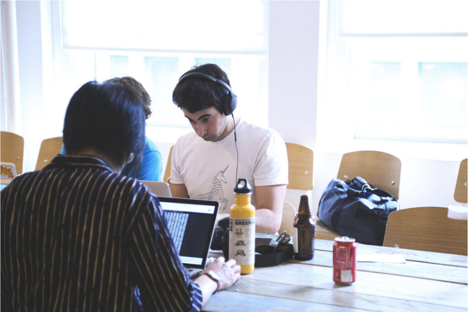 Auf dem Foto sind drei Menschen, die an einem Tisch sitzen und jeweils konzentriert am Laptop arbeiten. Ein Mensch sitzt mit dem Rücken zur fotografierenden Person. Die anderen beiden Personen sitzen nebeneinander an der gegenüberliegenden Tischseite und gucken zusammen in einen Laptop, wobei eine dieser Personen von dem Menschen bedeckt ist, der mit dem Rücken zur fotografierenden Person sitzt. © Servicestelle Jugendbeteiligung, 2021