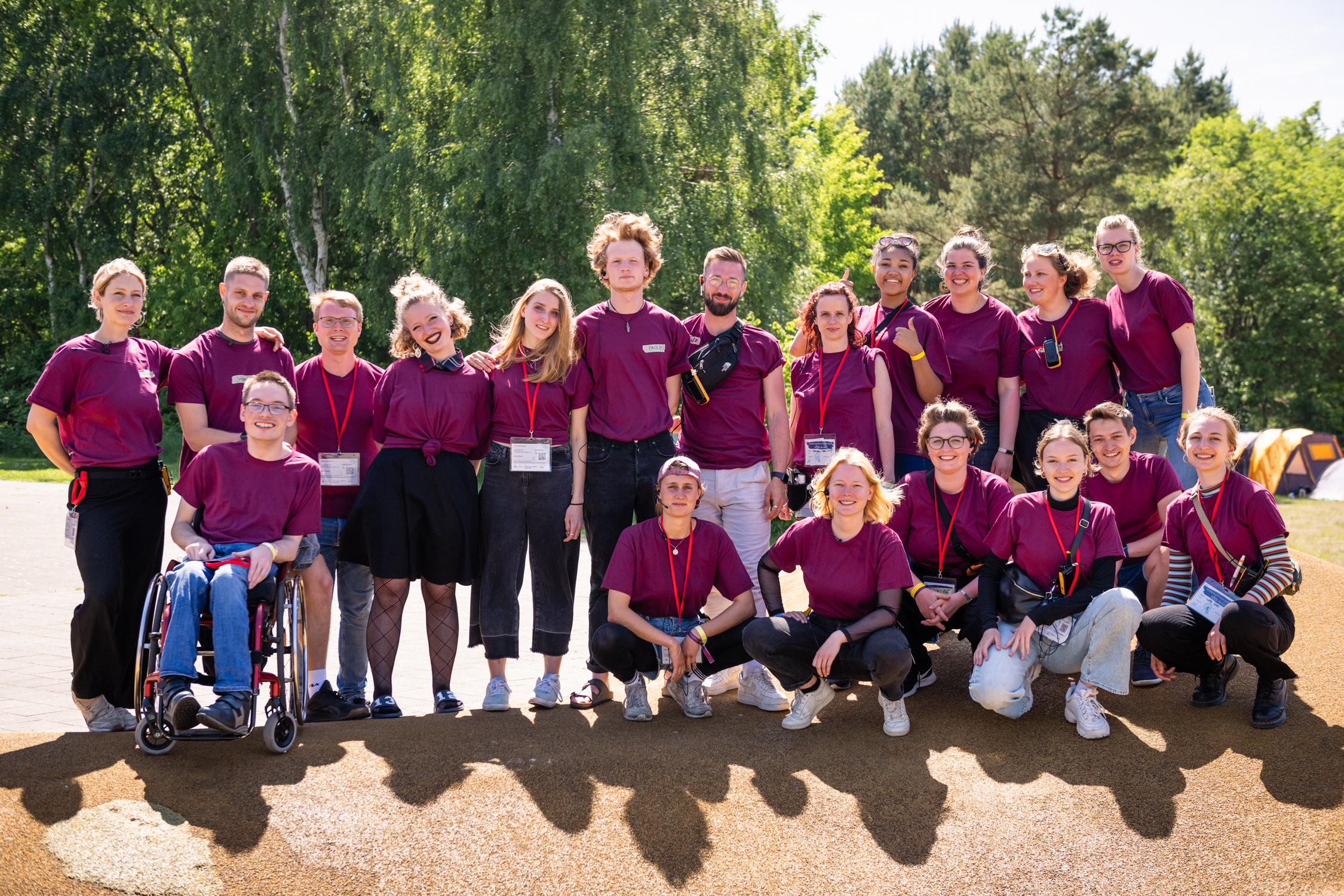 Das Bild zeigt viele junge Menschen, die in der Sonne stehen und in die Kammer lachen. Alle tragen dunkelrote T-Shirts mit dem Logo der Servicestelle Jugendbeteiligung.