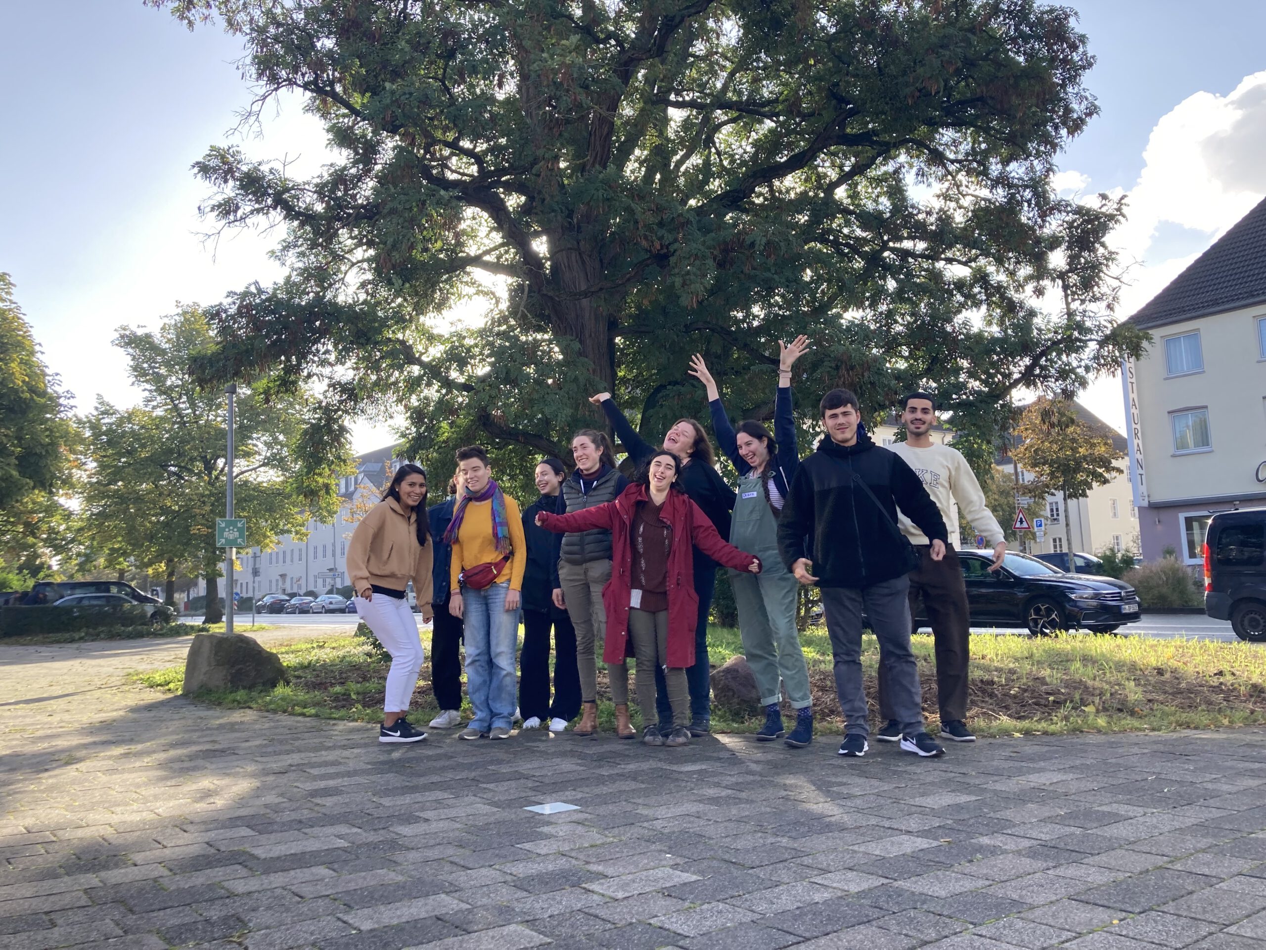 Das Bild zeigt eine Gruppe junger Menschen vor einem Baum.