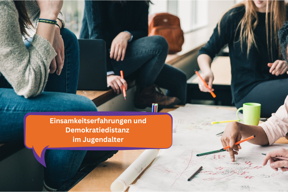 Im Hintergrund ist ein Ausblick auf mehrere Nicht identifizierbare Person. Sie sitzen zusammen um einen Tisch und arbeiten mit Laptops, Markern und Papier. Im Vordergrund ist eine Sprechblase in den Farben (orange und Lila), des veranstaltenden Vereins. Darin steht der Titel der Veranstaltung: ,,Einsamkeitserfahrungen und Demokratiedistanz im Jugendalter".