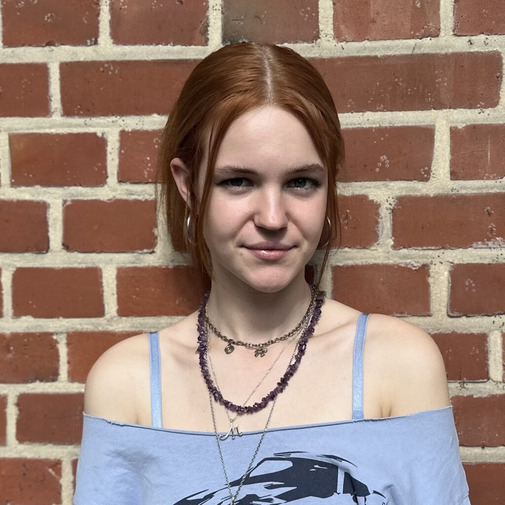 Das Bild zeigt die Geschäftsführung Lena. Sie steht vor einer mit Efeu bewachsenen Backsteinwand und lacht in die Kamera. © Servicestelle Jugendbeteiligung e.V., 2020 Das Bild zeigt die Geschäftsführung Lena. Sie steht vor einer mit Efeu bewachsenen Backsteinwand und lacht in die Kamera. © Servicestelle Jugendbeteiligung e.V., 2020