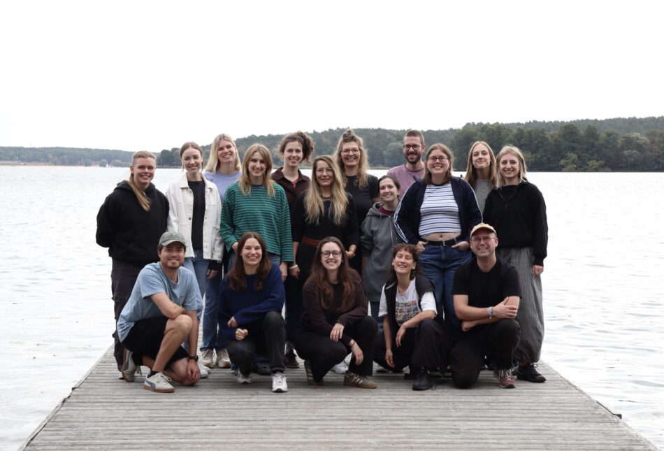 Gruppenbild von dem Team der SJB auf einem Steg. Alle blicken freundlich in die Kamera, vorne hocken 4 Personen, der Rest steht. Im Hintergrund ist in hellen und grauen Farben der Wannsee und ein kleiner Wald zu erkennen. © Servicestelle Jugendbeteiligung e.V., 2026