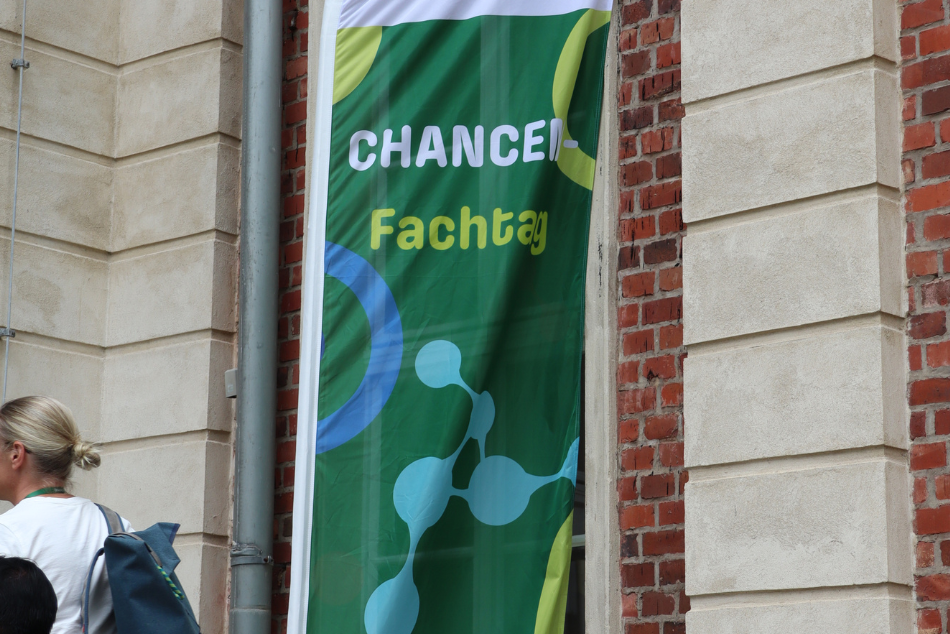 Fahnenständer mit grüner Flagge. Aufschrift mit "CHANCEN-Fachtag 2026".